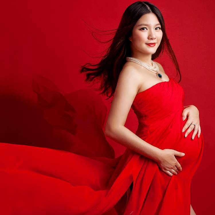 hamile kadının kırmızı elbise giymesi