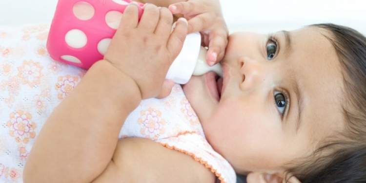 kız bebeğe biberonla süt vermek